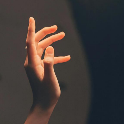 Hand reaching toward light — the science and presence of touch